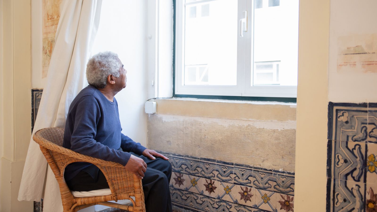 An older man looking out a window